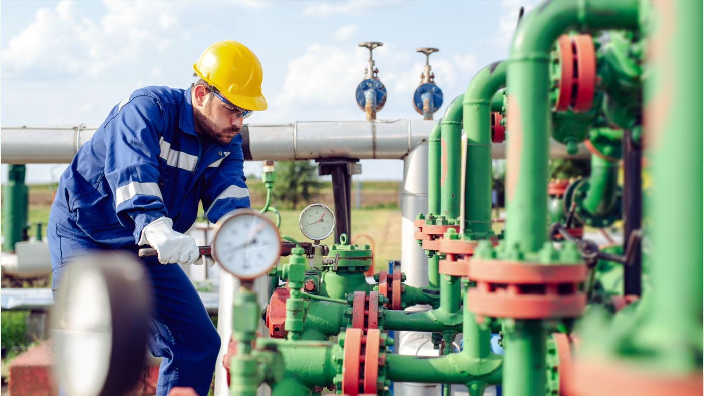 Field technician adjusting a wellhead valve